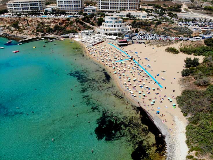 Mellieha is the best place to stay in Malta if you are lokin gfor a beach holiday. In the background is a hotel or apartment complex overlooking the best beach on Malta island.