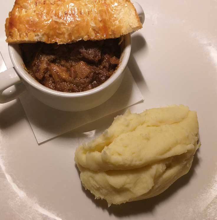 Steak and mushroom pot pie with mashed potatoes on a plate - my first hotel quarantine dinner